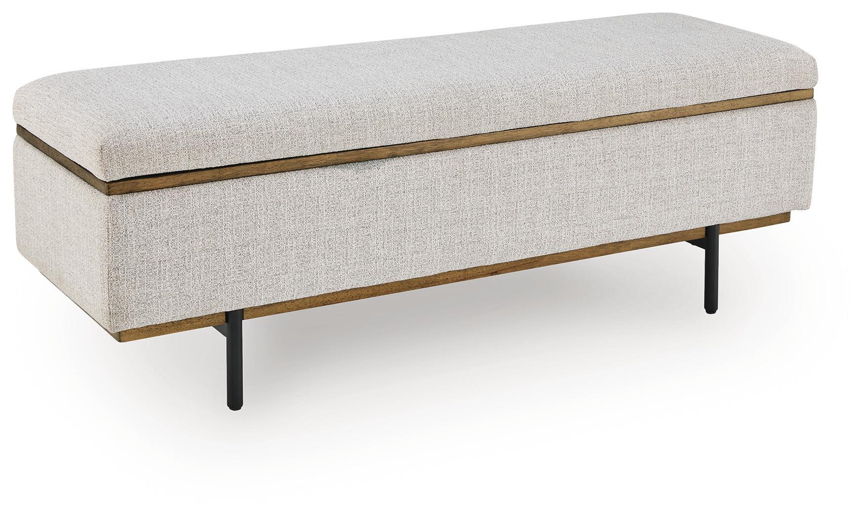 Stone upholstered storage bench with gold trim and dark tapered legs, hinged lid