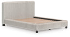 White upholstered bed with vertical channel headboard, platform base, and beige mattress.