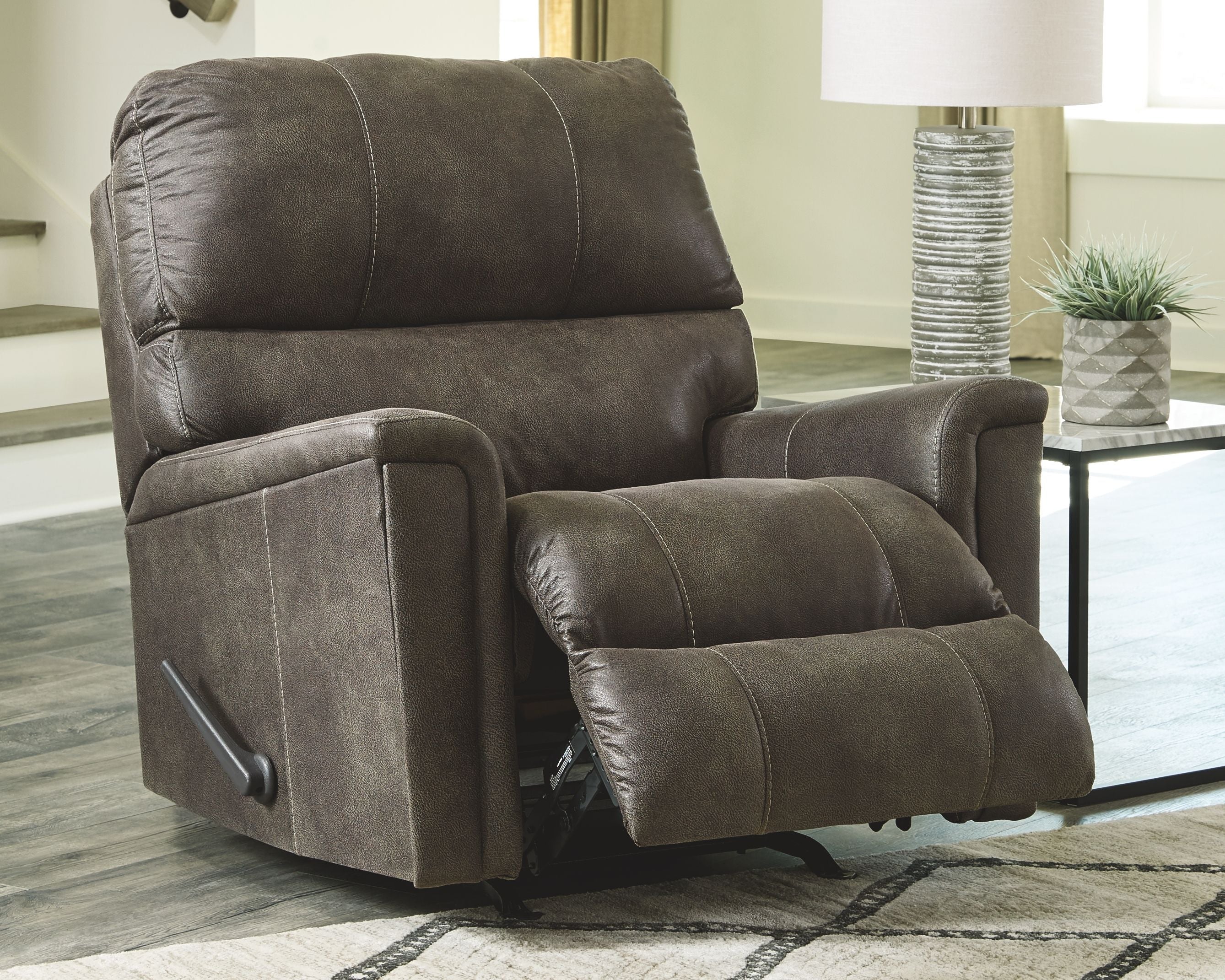 Dark gray recliner chair with padded armrests and tufted backrest