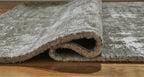 Dark gray rug close-up: textured rolled edge with low pile and bound backing