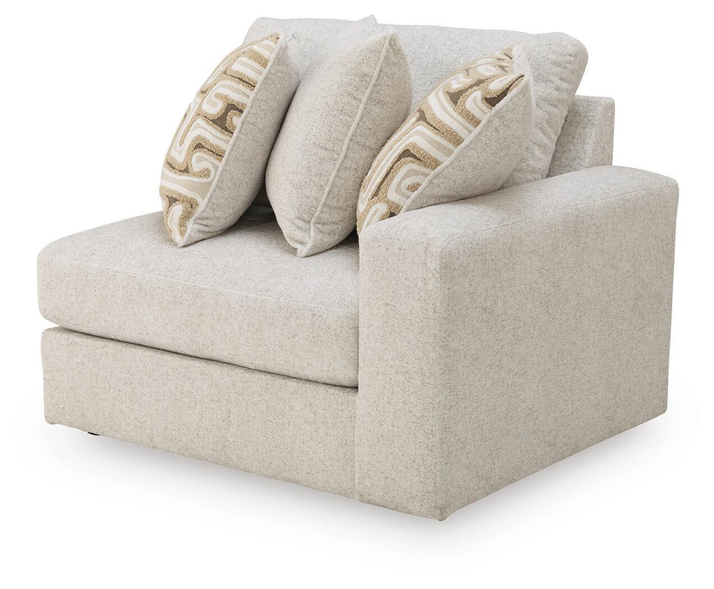Light beige upholstered corner chair with wide arms and two patterned throw pillows