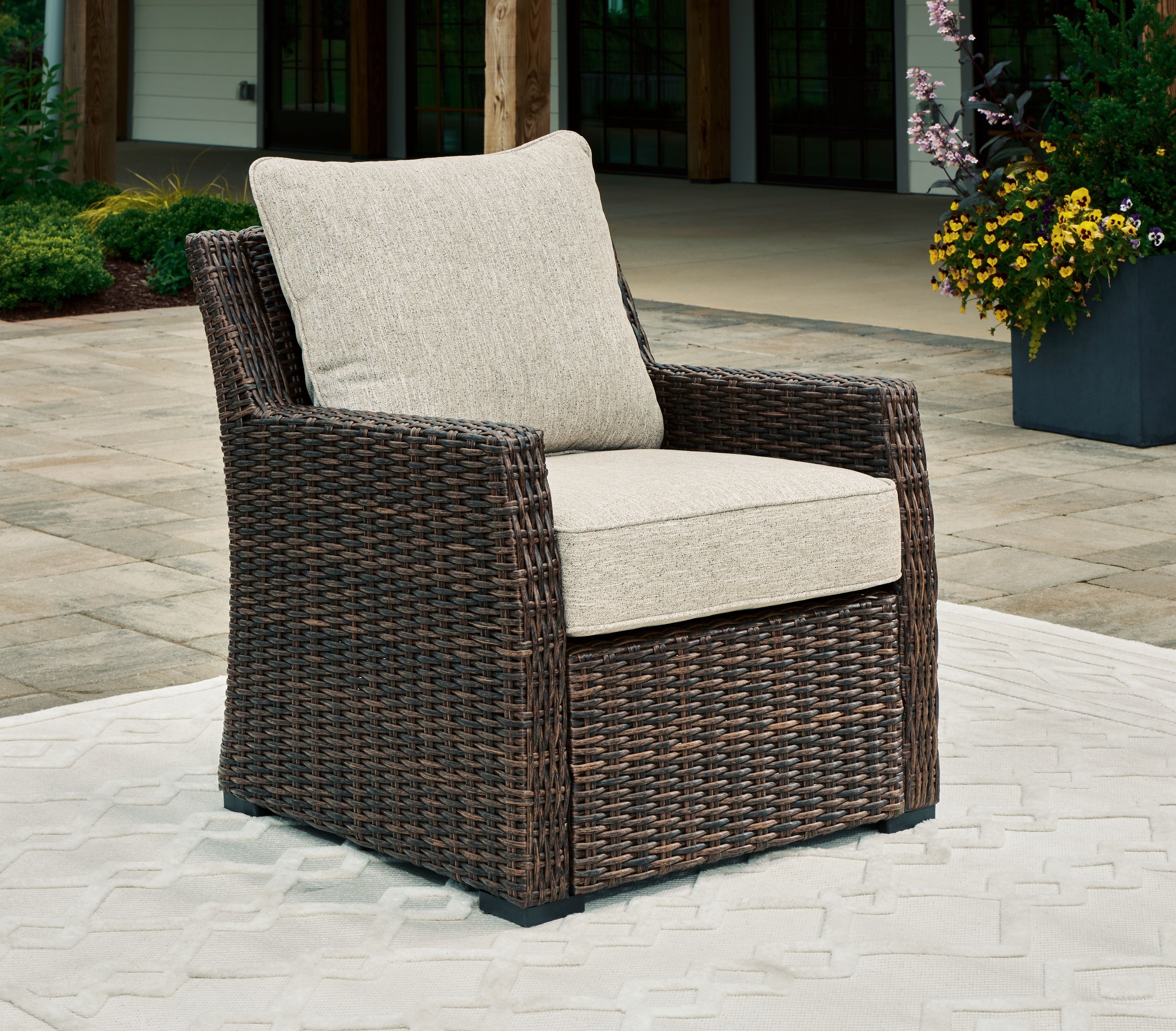 Brown woven lounge chair with light beige seat and back cushion
