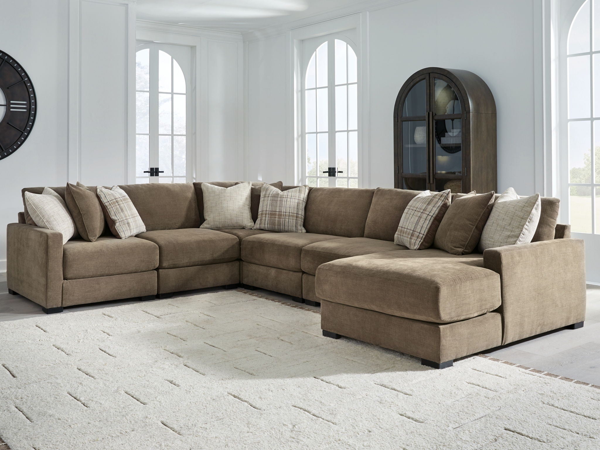 Coffee-brown sectional sofa with right chaise and multiple throw pillows in a living room setup