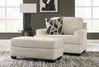 Beige upholstered loveseat with patterned throw pillows and matching ottoman