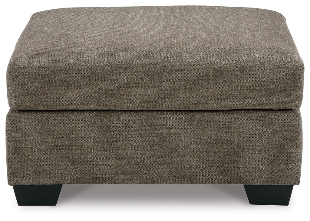Oversized ottoman with dark brown fabric, thick cushioned seat, and squared black legs.
