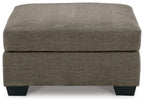 Oversized ottoman with dark brown fabric, thick cushioned seat, and squared black legs.