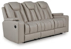 Reclining sofa in light beige upholstery with padded arms and tufted back