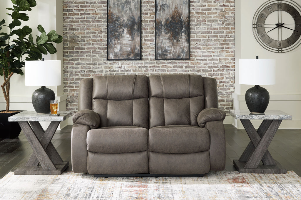 Gunmetal reclining loveseat with tufted back cushions and rounded armrests, side view