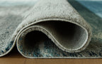Blue area rug rolled edge showing short pile and stitched border, underside