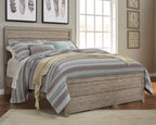 Gray upholstered panel bed frame with tall headboard and storage drawers, with striped bedding