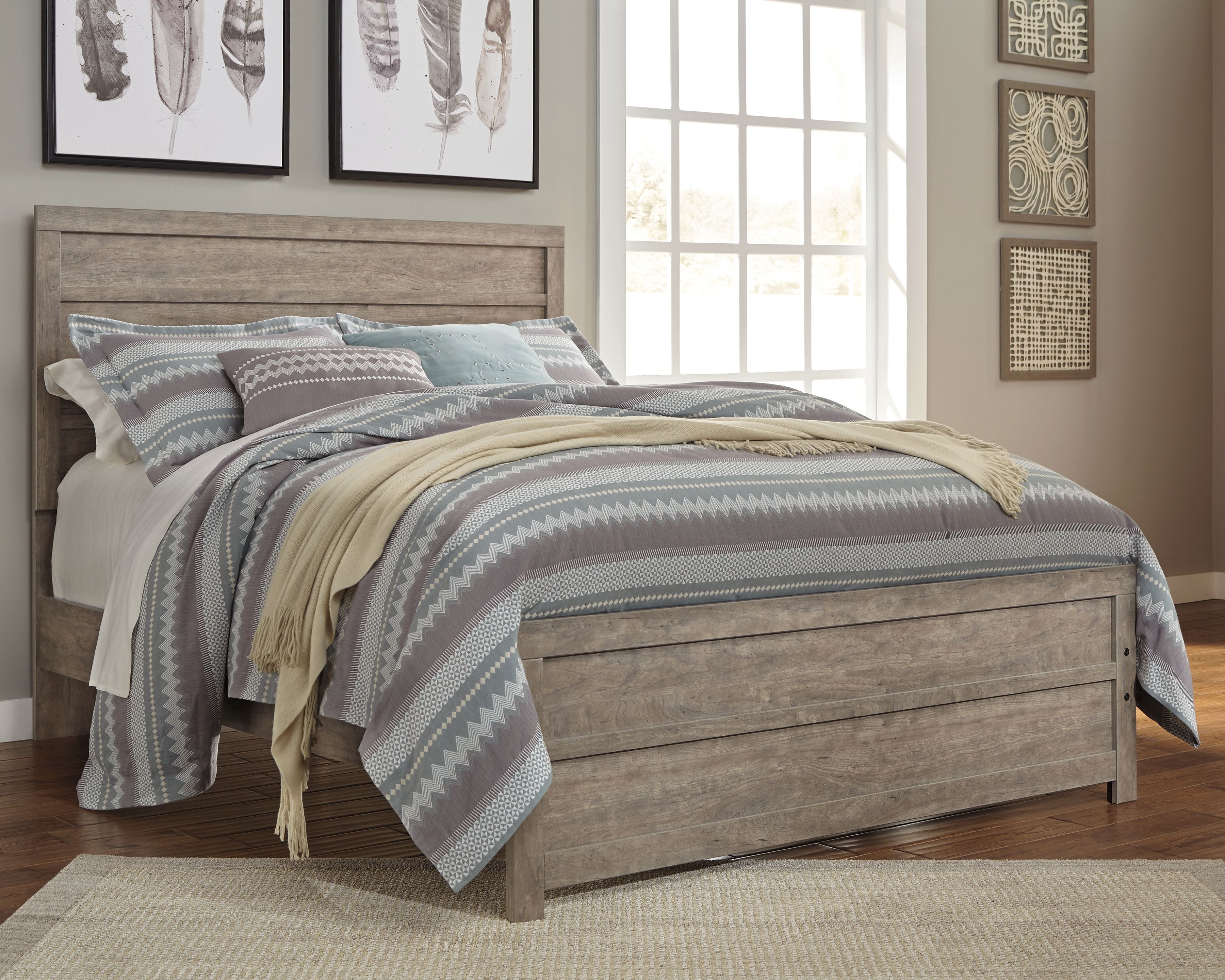 Gray upholstered panel bed frame with tall headboard and storage drawers, with striped bedding