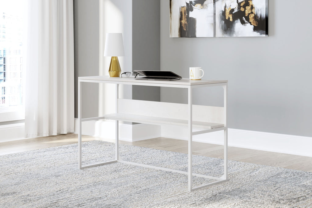 White home office desk with open shelf, shown styled with laptop and decor