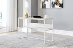 White home office desk with open shelf, shown styled with laptop and decor