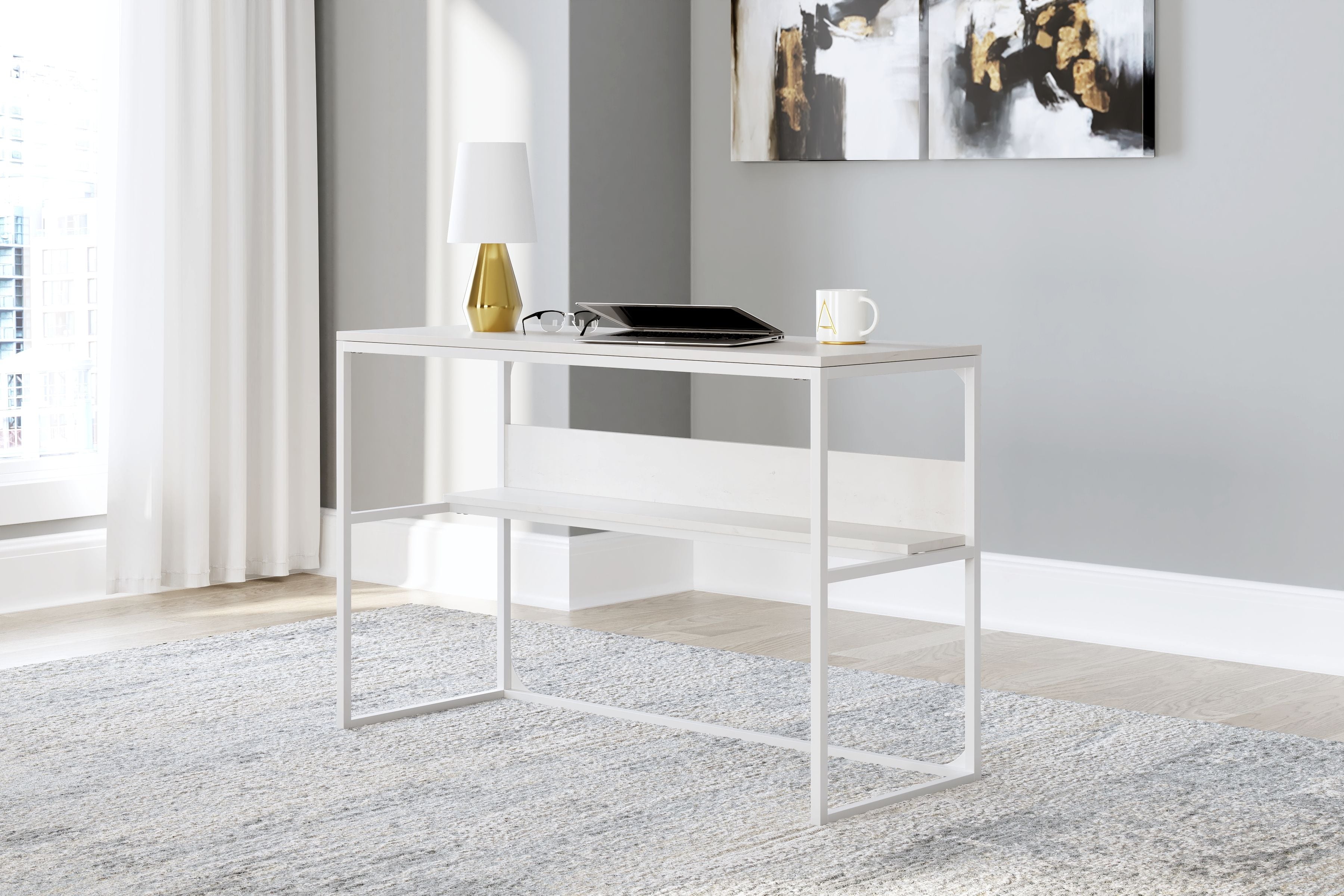 White home office desk with open shelf, shown styled with laptop and decor