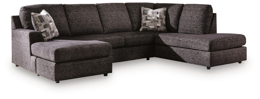 Dark charcoal fabric sectional with chaise seating, low arms, and two back accent pillows