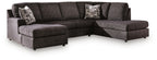 Dark charcoal fabric sectional with chaise seating, low arms, and two back accent pillows