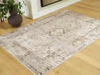 Washable rug with distressed geometric pattern and central medallion in light tones
