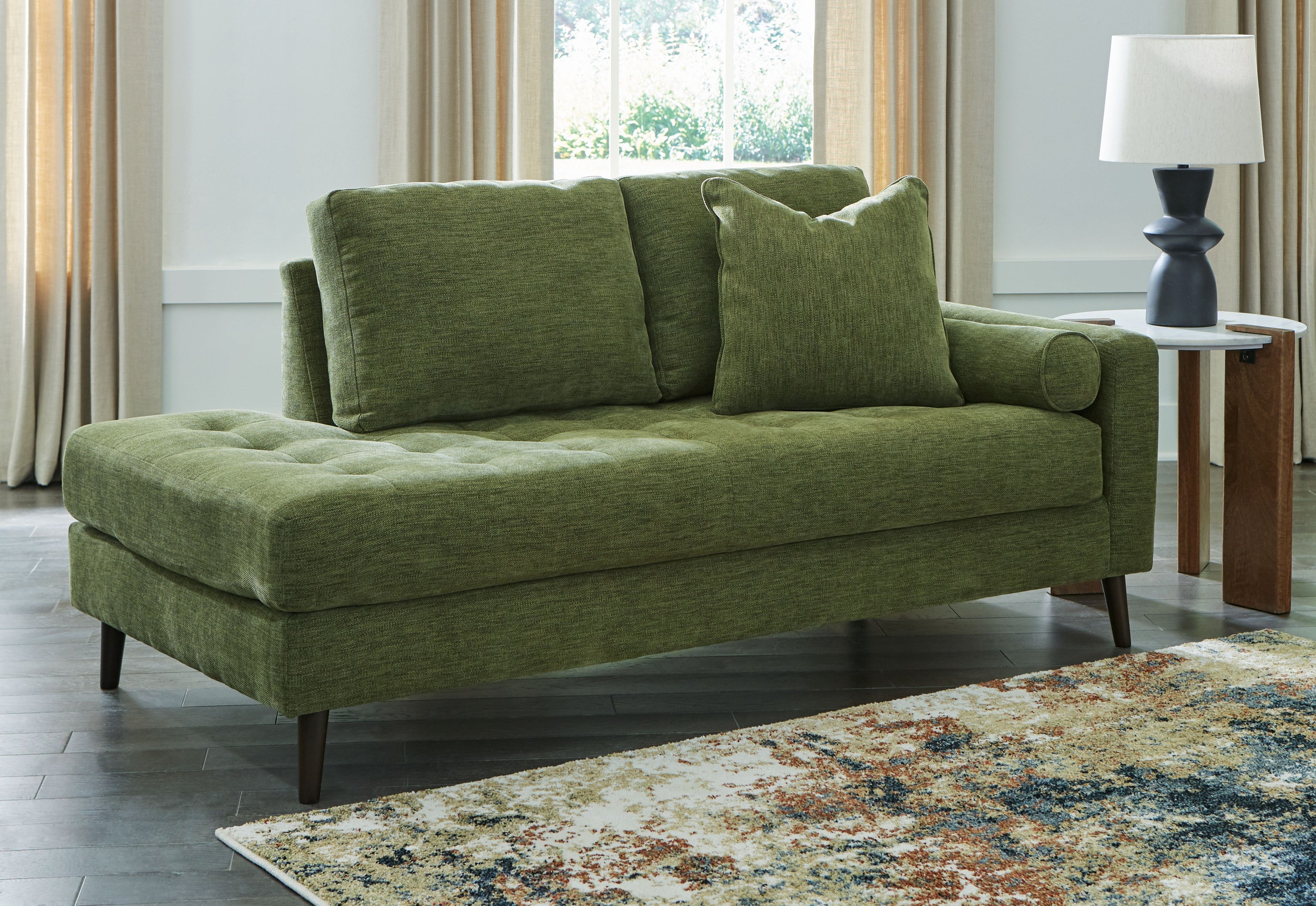 Green corner chaise sofa with tufted back cushions and dark tapered legs