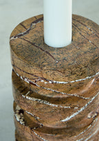 Tan marble candle holder close-up, round top opening with white veining