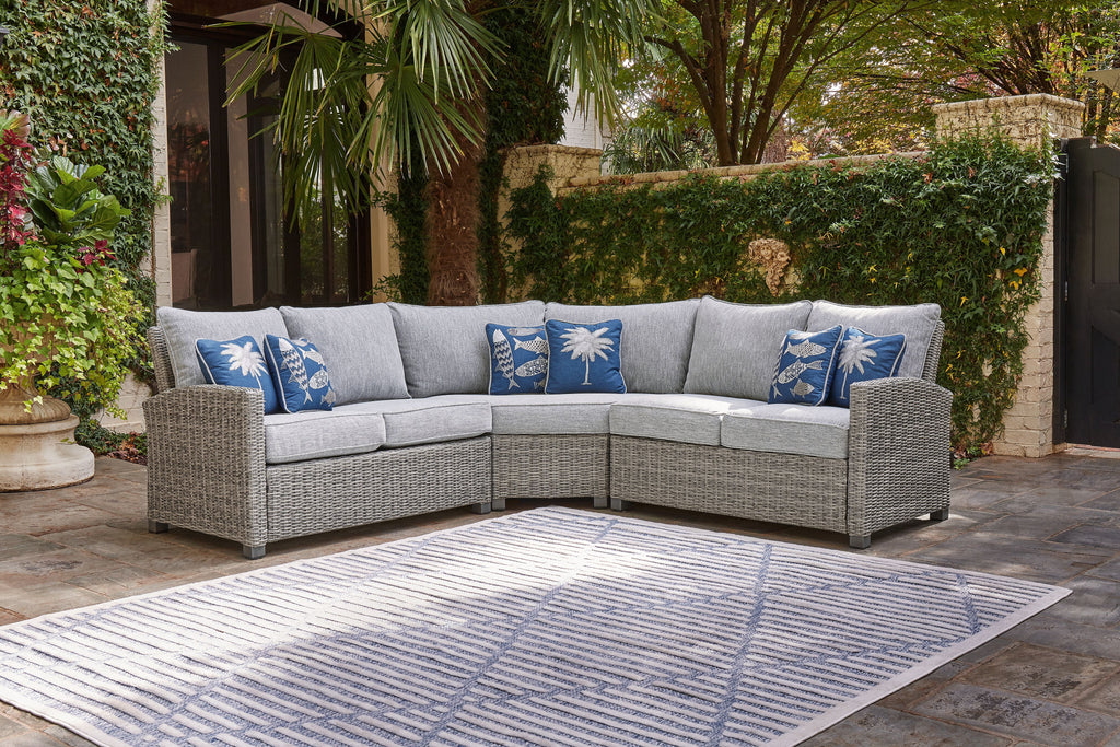 Light gray corner sectional sofa with blue palm and fish patterned pillows