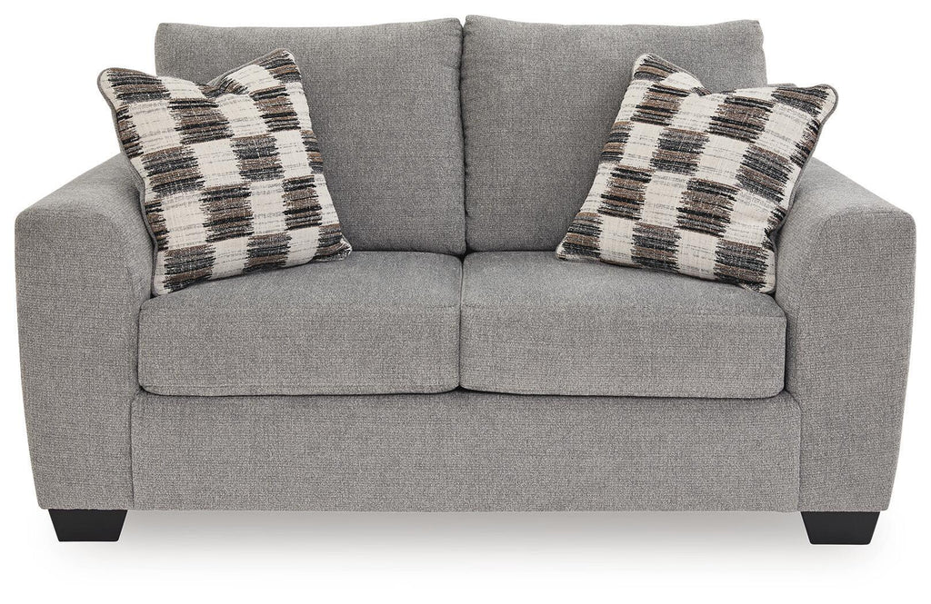 Medium gray loveseat with two plaid throw pillows and split seat cushions