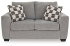 Medium gray loveseat with two plaid throw pillows and split seat cushions
