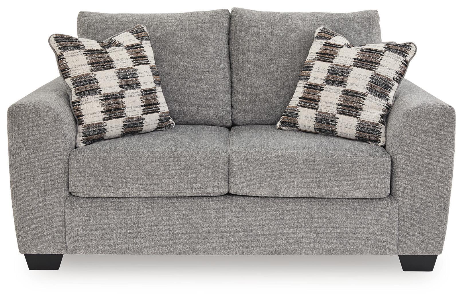 Medium gray loveseat with two plaid throw pillows and split seat cushions