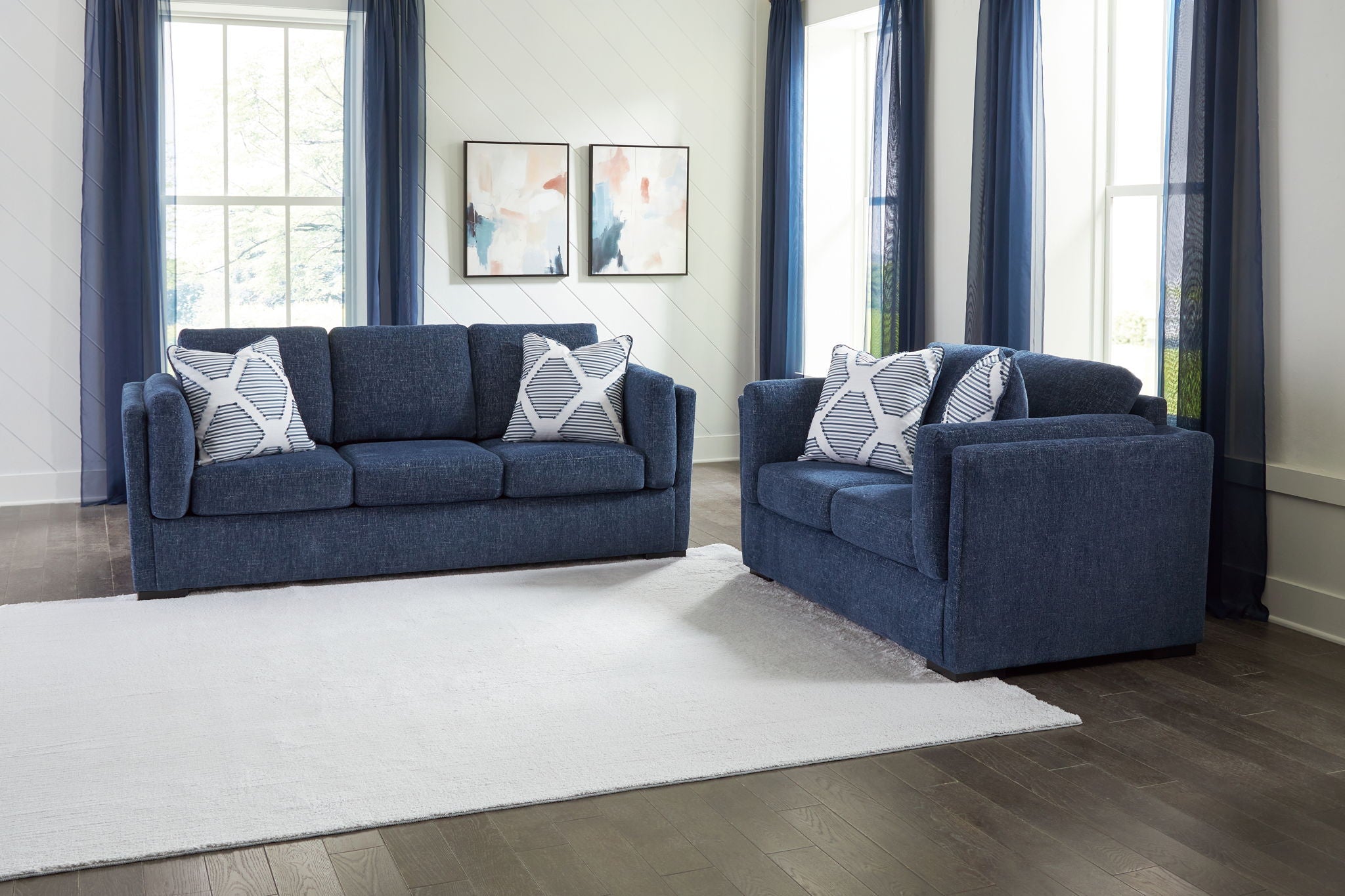 Blue living room sofa set with loveseat and armchair featuring patterned throw pillows