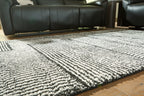Black-and-white striped geometric rug with textured pile.