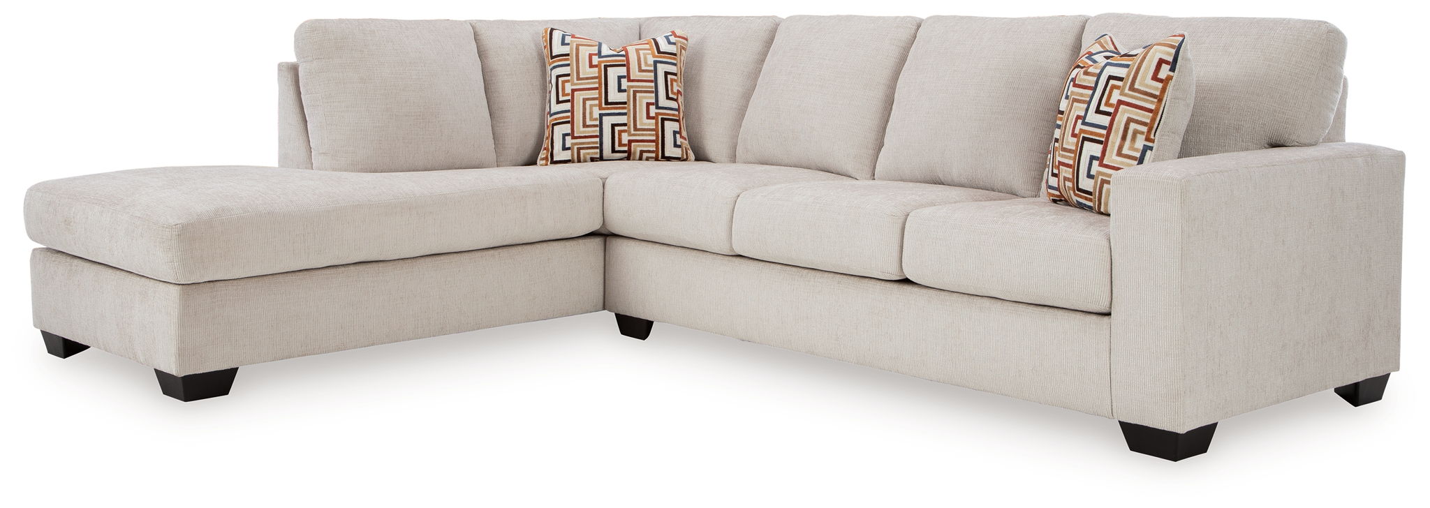 Light beige sectional sofa corner with box cushions and two patterned throw pillows