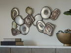Multi-piece wall decor cluster of resin stone discs with concentric rings in cream and gray