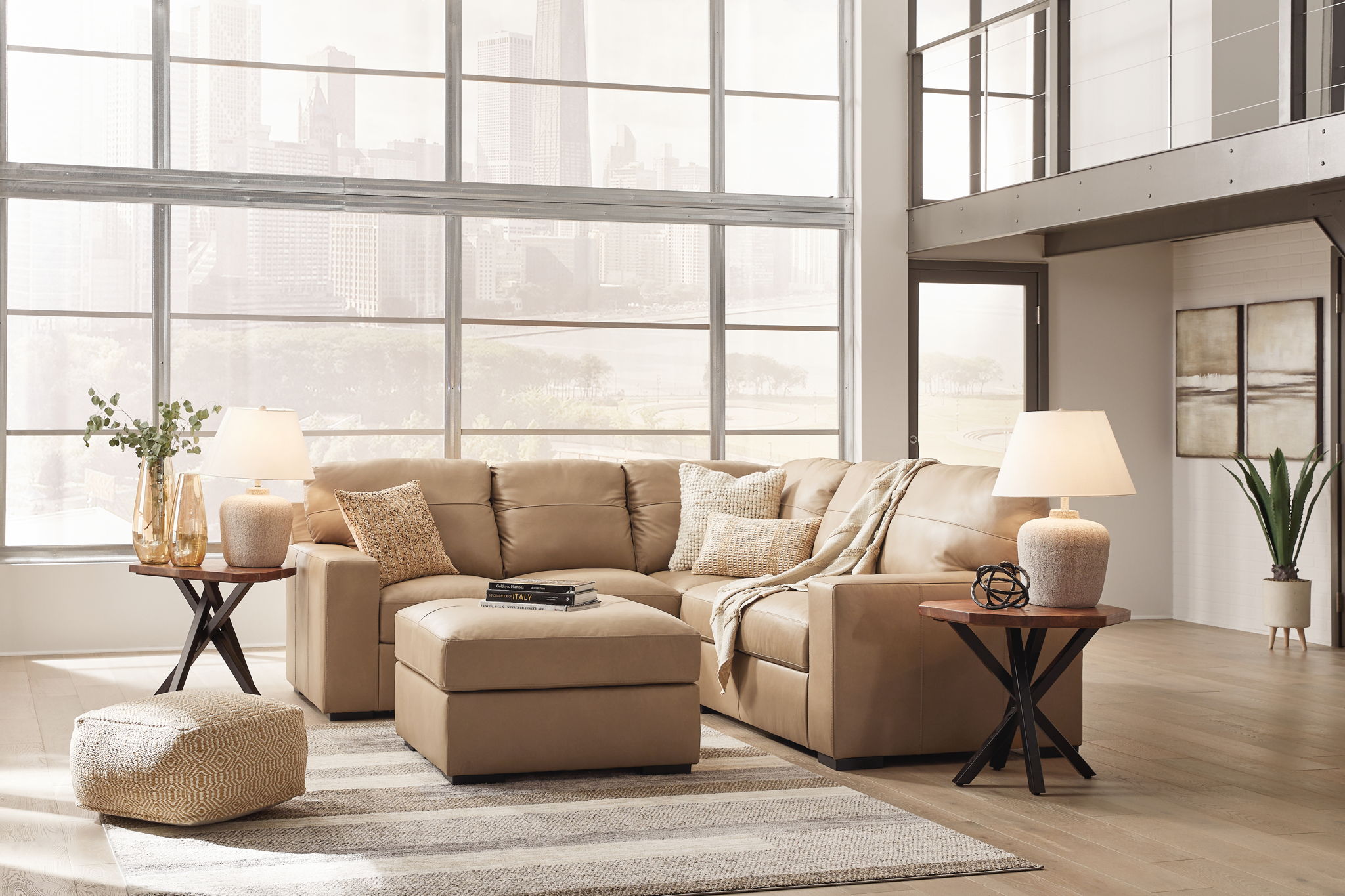 Light brown fabric sectional sofa with chaise and ottoman in a neutral layout