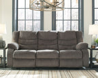 Gray reclining sofa with three seat sections, tufted back cushions, and recliner arms