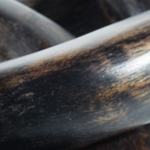 Close-up of dark chain link sculpture with a rounded oval opening