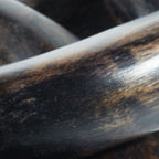 Close-up of dark chain link sculpture with a rounded oval opening