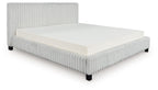 Upholstered bed with light gray ribbed headboard and sides, white mattress