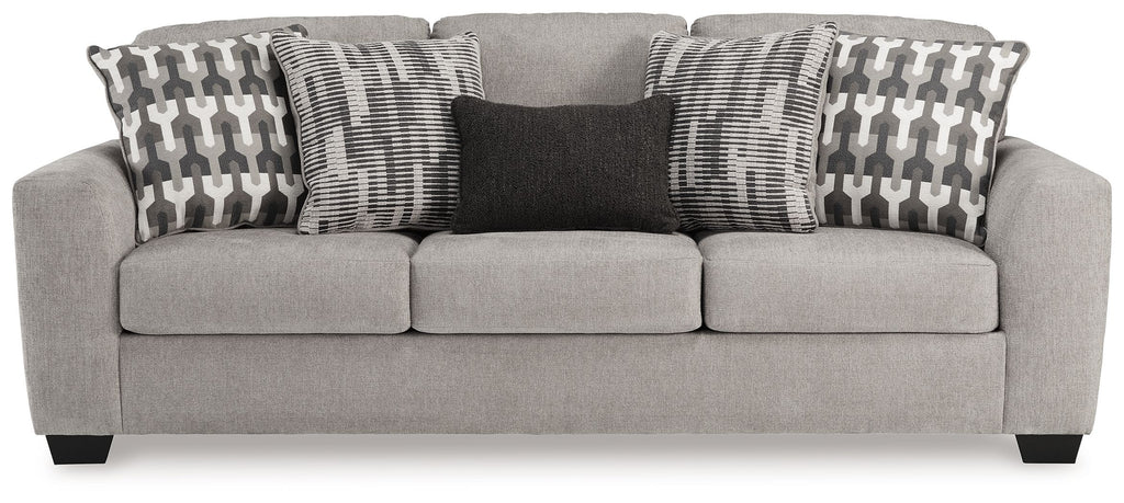 Gray flannel sofa with three seat cushions and geometric throw pillows