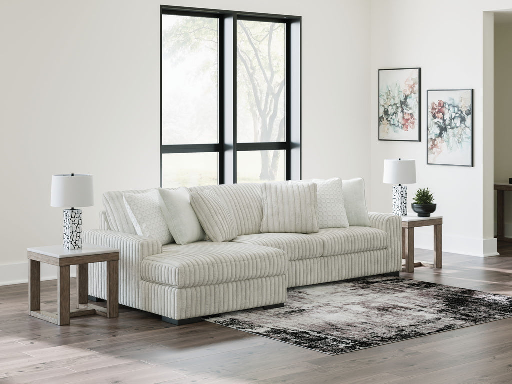 Off-white striped sectional sofa with chaise and stacked back pillows.