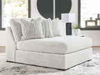 Oversized armless chaise in light gray textured fabric with two throw pillows