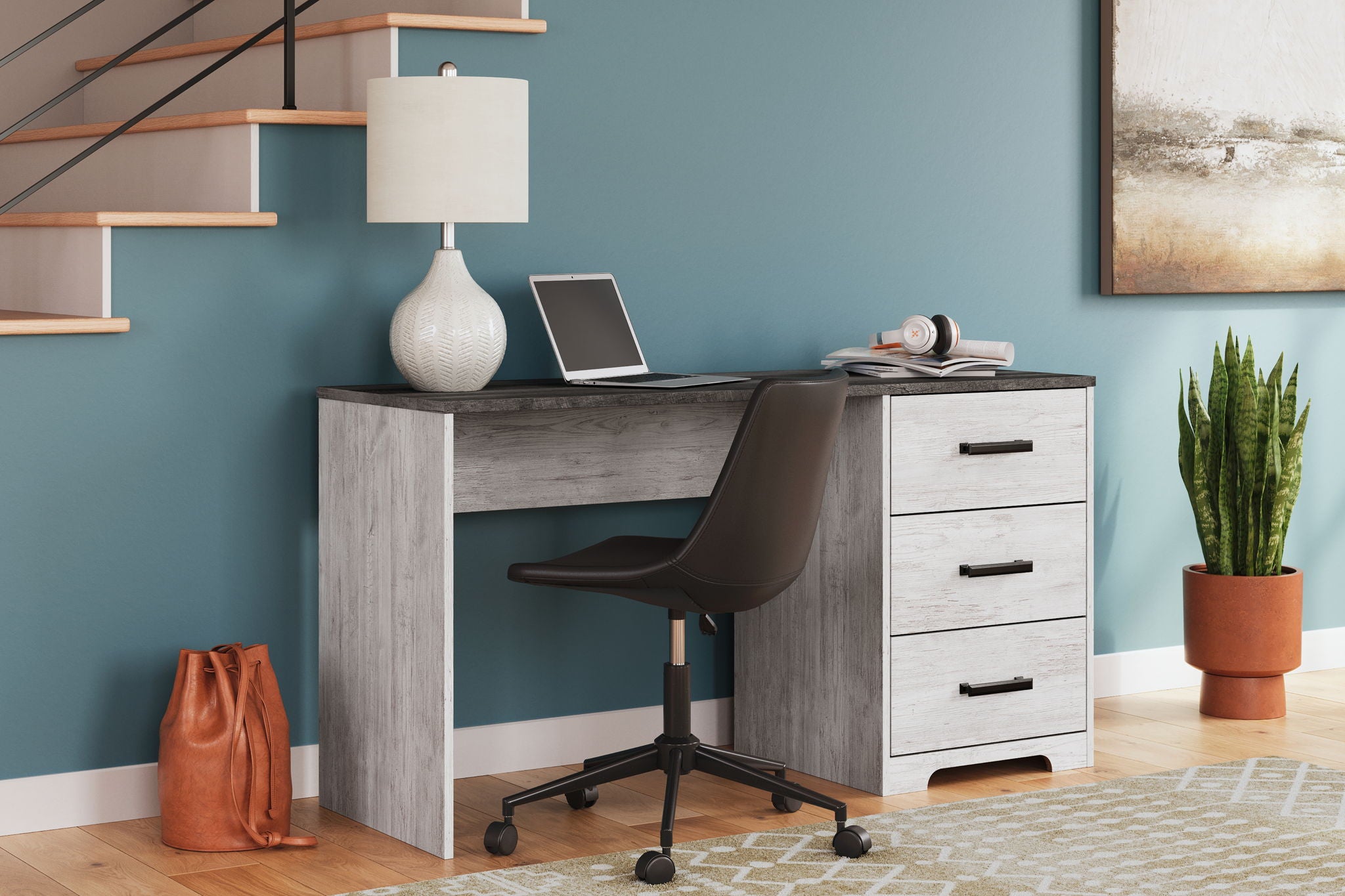 Home office desk with light gray wood-look body, dark top, three drawers, office chair