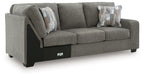 Grey RAF corner wedge sofa with two throw pillows and padded seat cushions