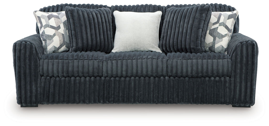 Dark gray corduroy sofa with two patterned throw pillows and a light center back cushion.