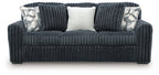 Dark gray corduroy sofa with two patterned throw pillows and a light center back cushion.