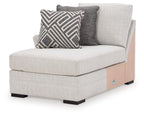 Stone gray corner chaise with square arm and patterned throw pillow