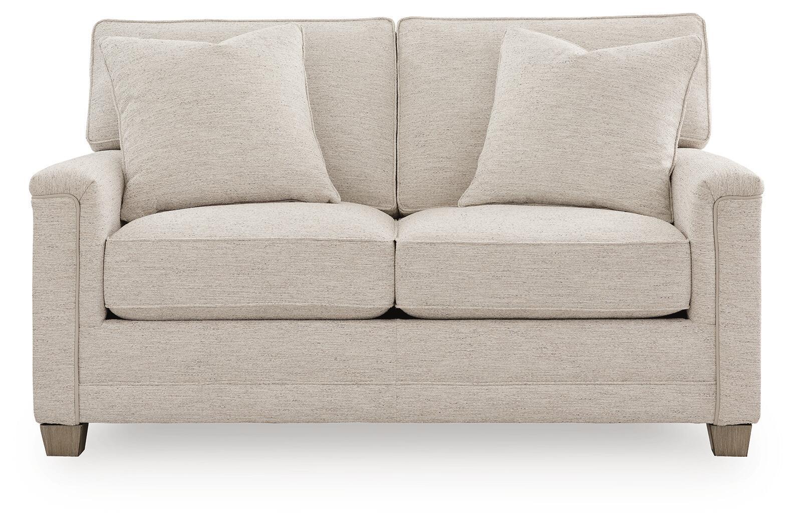Light beige upholstered loveseat with two seat cushions and three back pillows