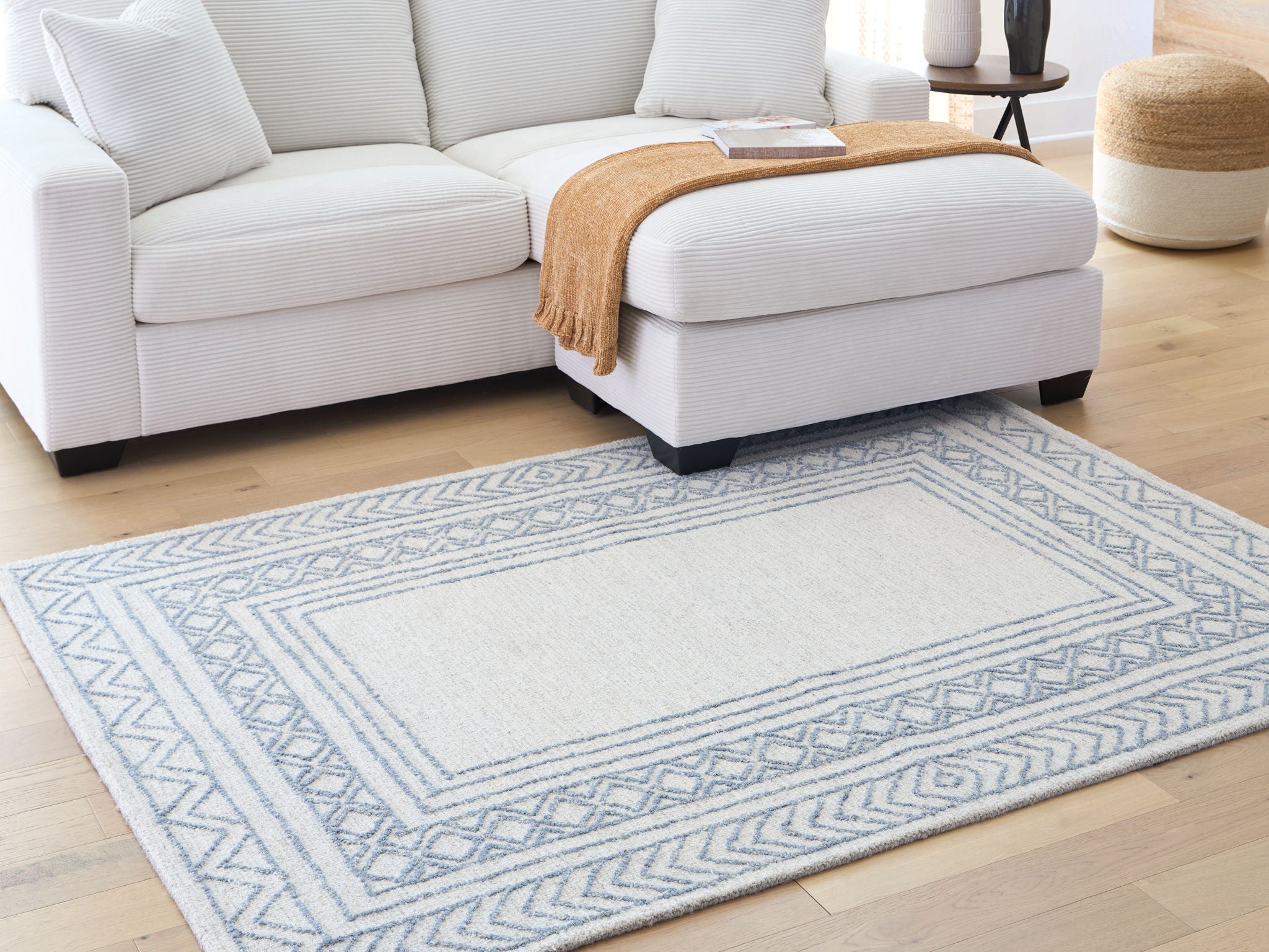 Geometric blue rug with border pattern, displayed in living room