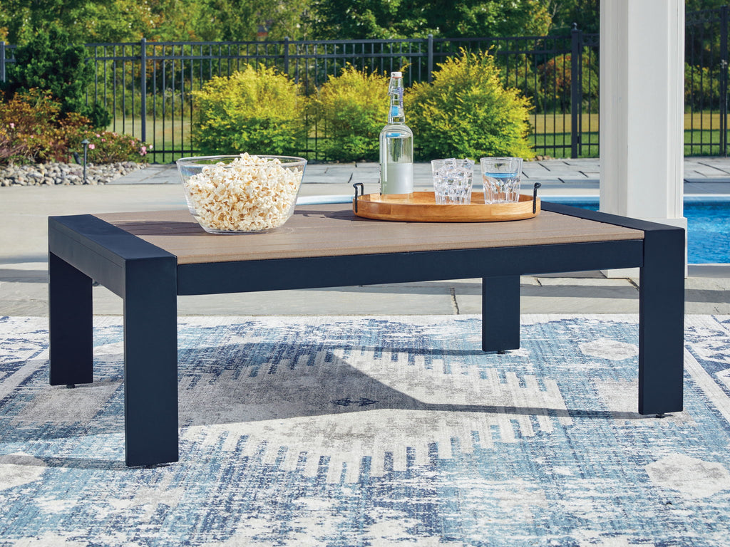 Blue rectangular cocktail table with slatted beige top, dark frame, and bottle decor