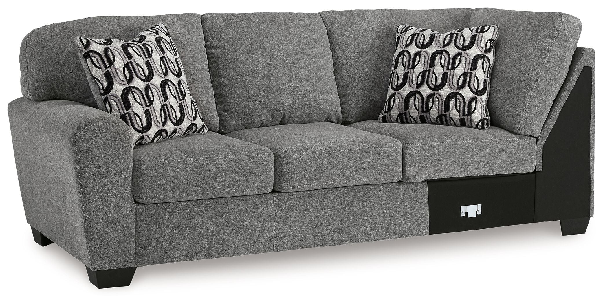 Gray sofa with corner wedge, two patterned throw pillows, and dark base panels