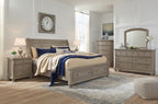 Gray dresser with arched mirror and multiple drawers, styled in bedroom setting