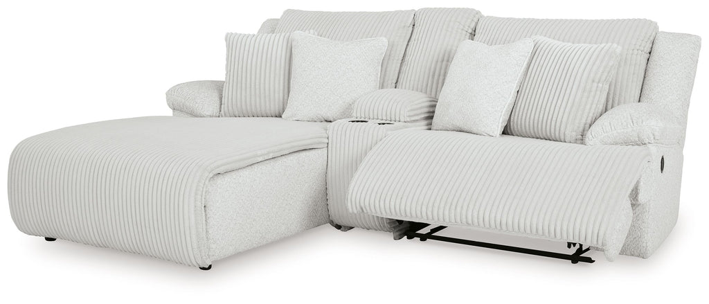 White ribbed reclining sectional sofa with chaise, pillows, and armrests